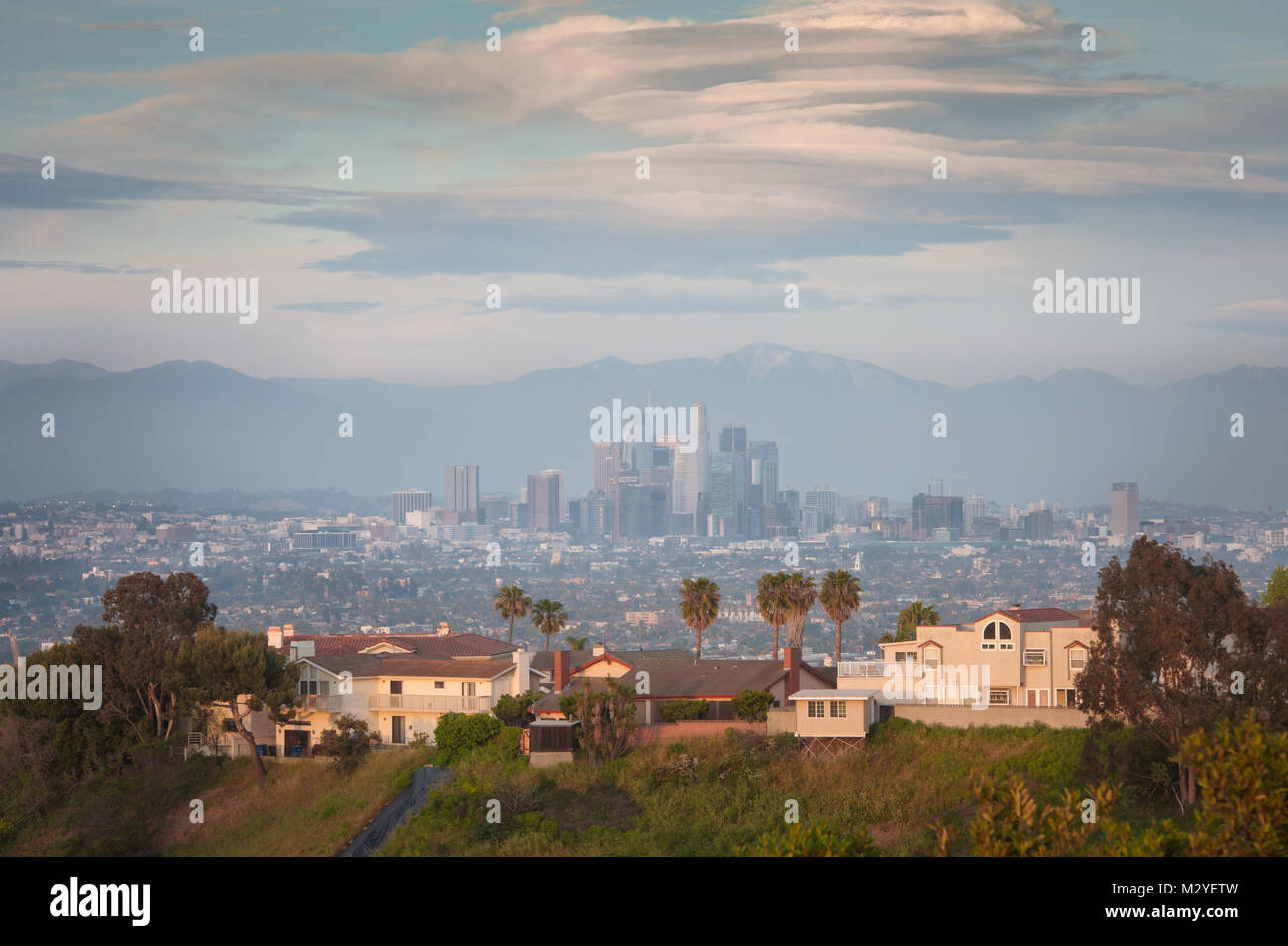 Vista del centro della città di L.A con case in primo piano fotografata al tramonto dalla cima del Kenneth Hahn membro Recreation Area di Los Angeles, CA. Foto Stock