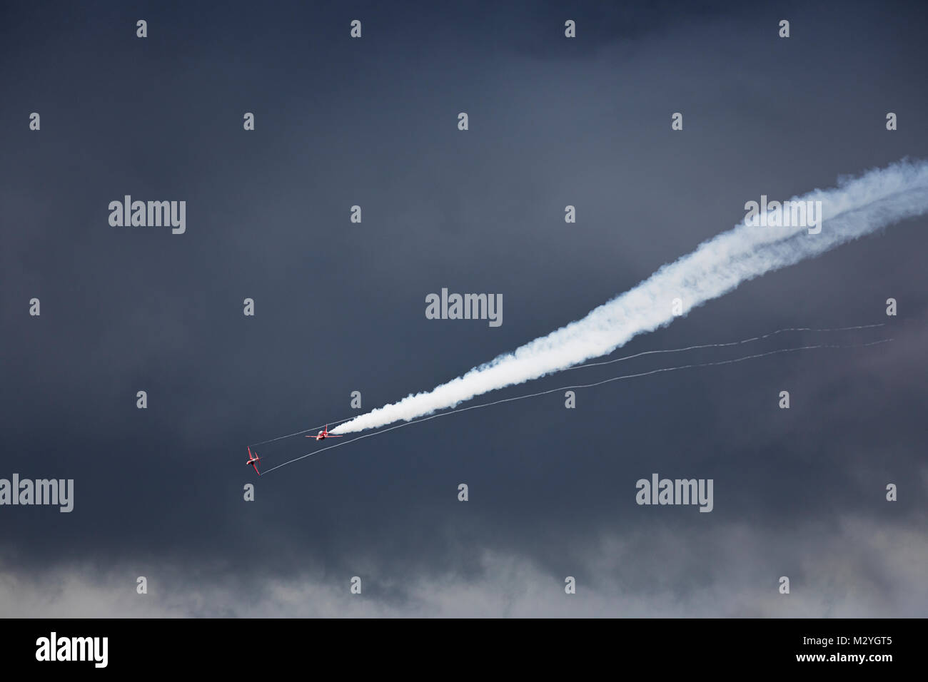 Una coppia di Royal Air Force frecce rosse Hawks battono contro un cielo tempestoso Foto Stock