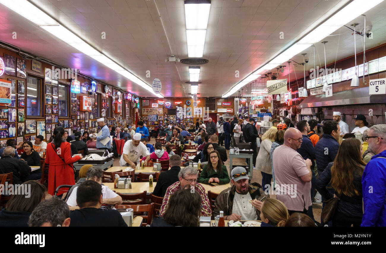 I clienti di server e attendere il personale occupato, affollata sala da pranzo a Katz's Delicatessen, una famosa New York City ristorante casual. Foto Stock