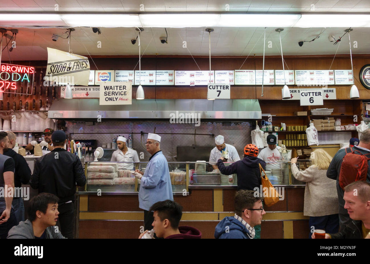 I clienti, i server e il servizio di cucina presso il contatore a Katz's Delicatessen, una famosa città di New York deli Ebreo ristorante. Foto Stock