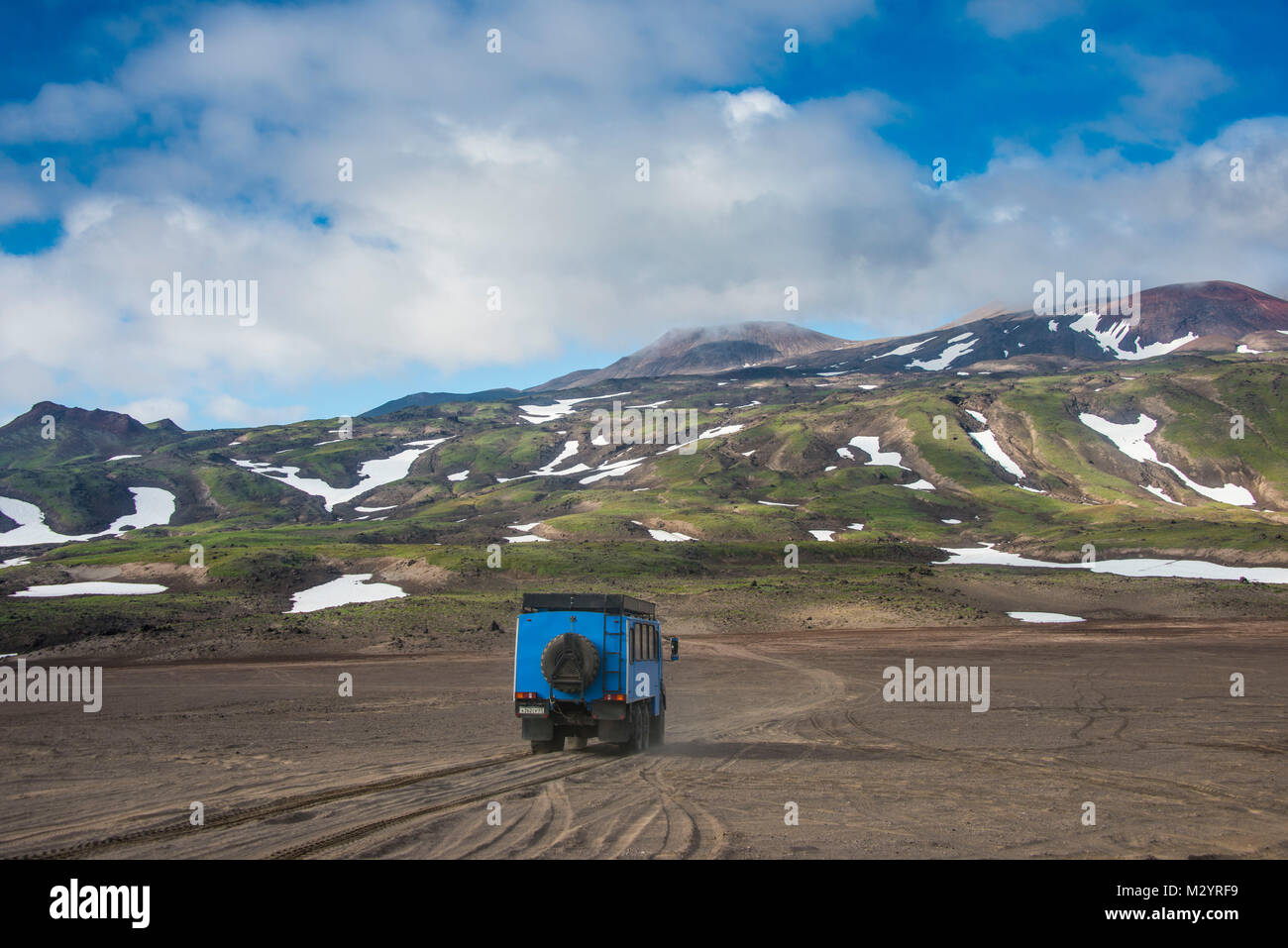 Carrello di guida attraverso la sabbia lavica, vulcano Gorely, Kamchatka, Russia Foto Stock