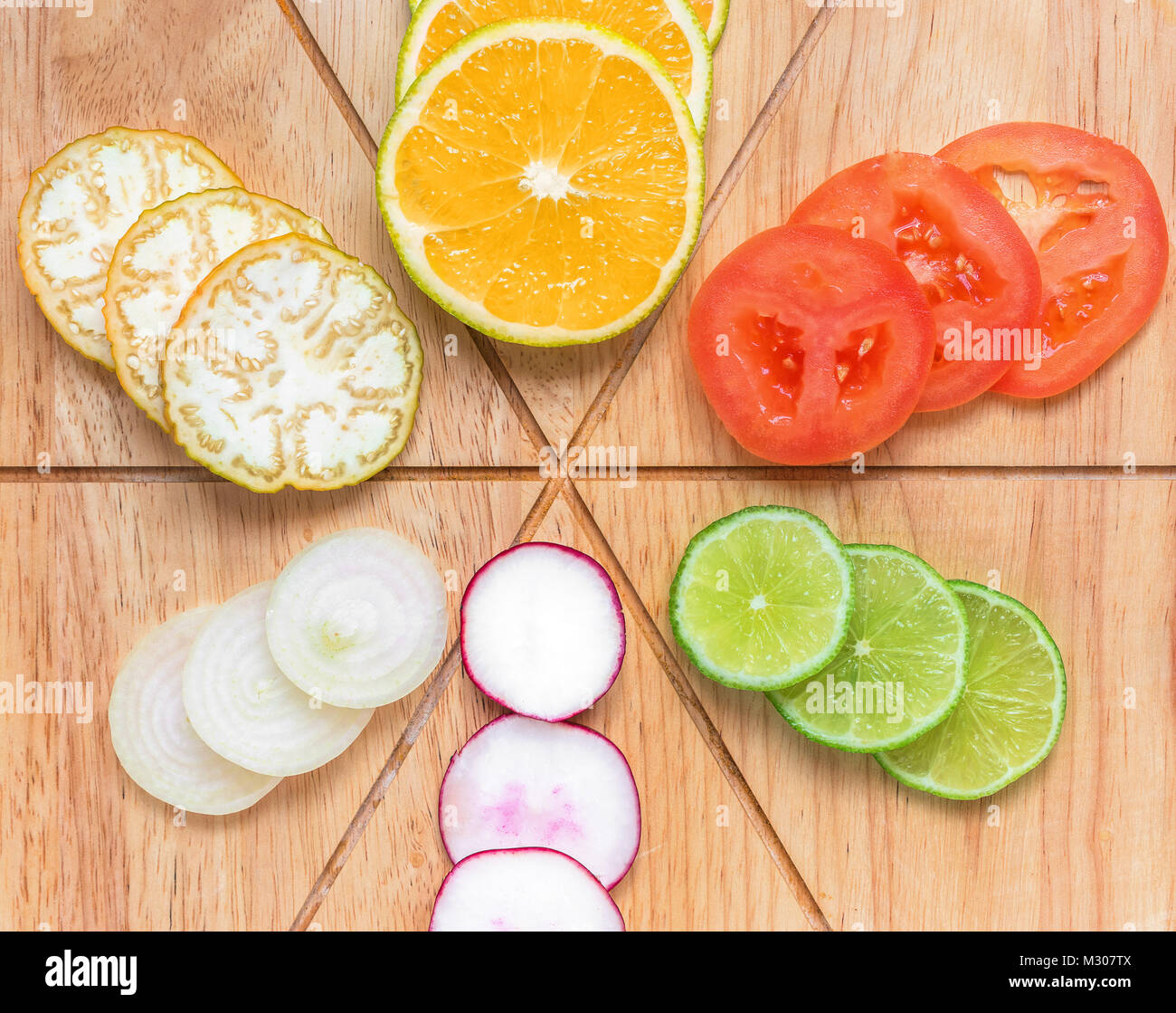 Vario e varie di frutta e verdura, organizzato sulla parte superiore di una tavola di legno, diviso e tagliare, comprese le arance, melanzana, pomodoro, cipolla, limone Foto Stock