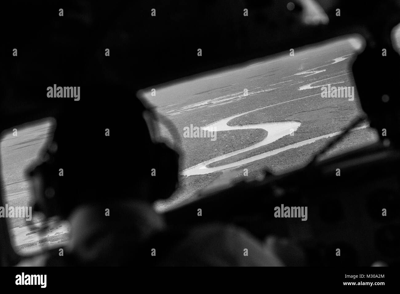 Una compagnia aerea colombiana pilota, vola un Douglas DC-3 velivolo sopra la foresta pluviale di canali del fiume vicino la giungla aeroporto di Puerto Inírida, Colombia. Foto Stock