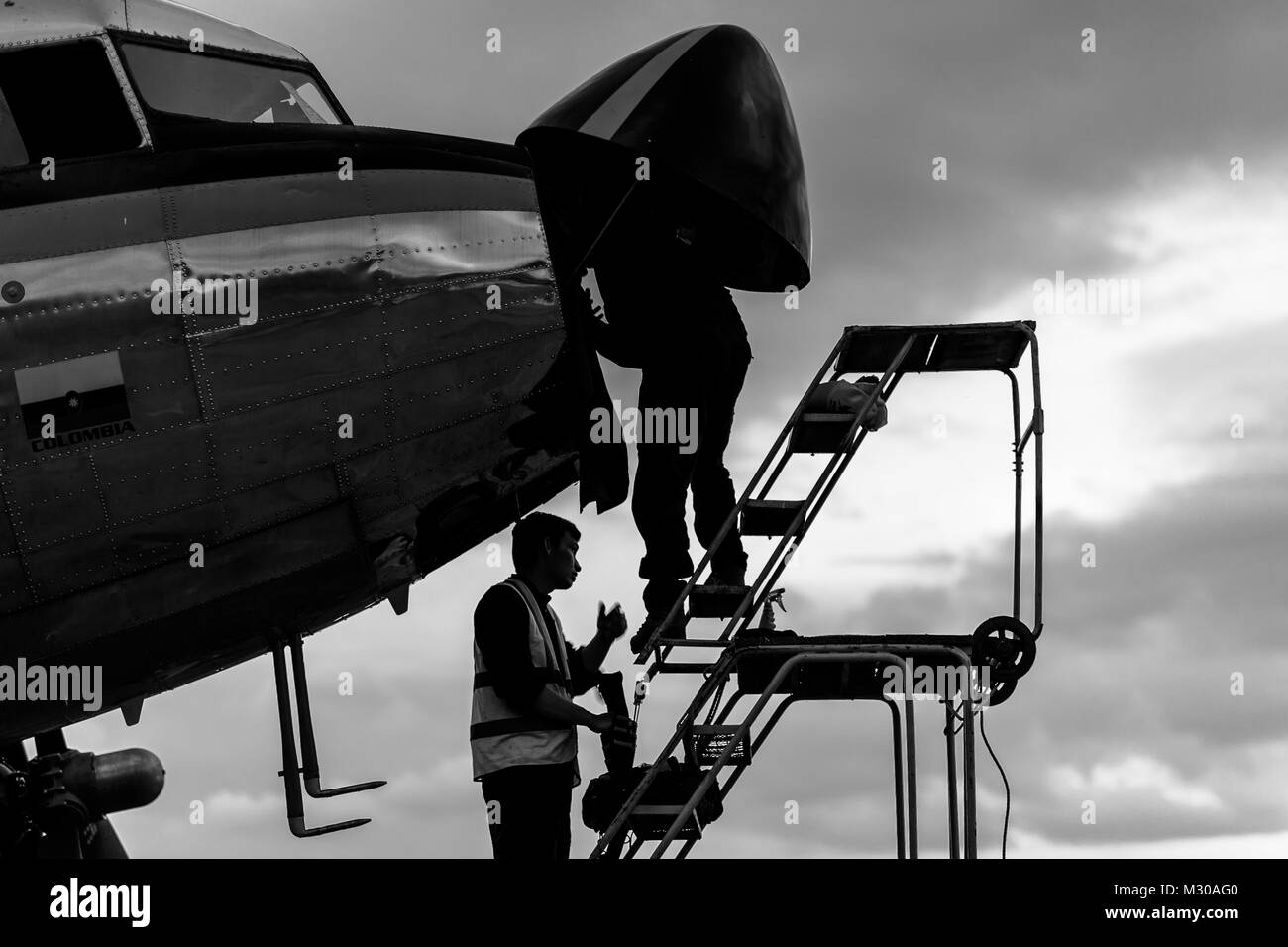 Meccanica colombiano lavorare su un aereo di naso durante un controllo di manutenzione di un Douglas DC-3 velivolo all'aeroporto di Villavicencio (Colombia). Foto Stock