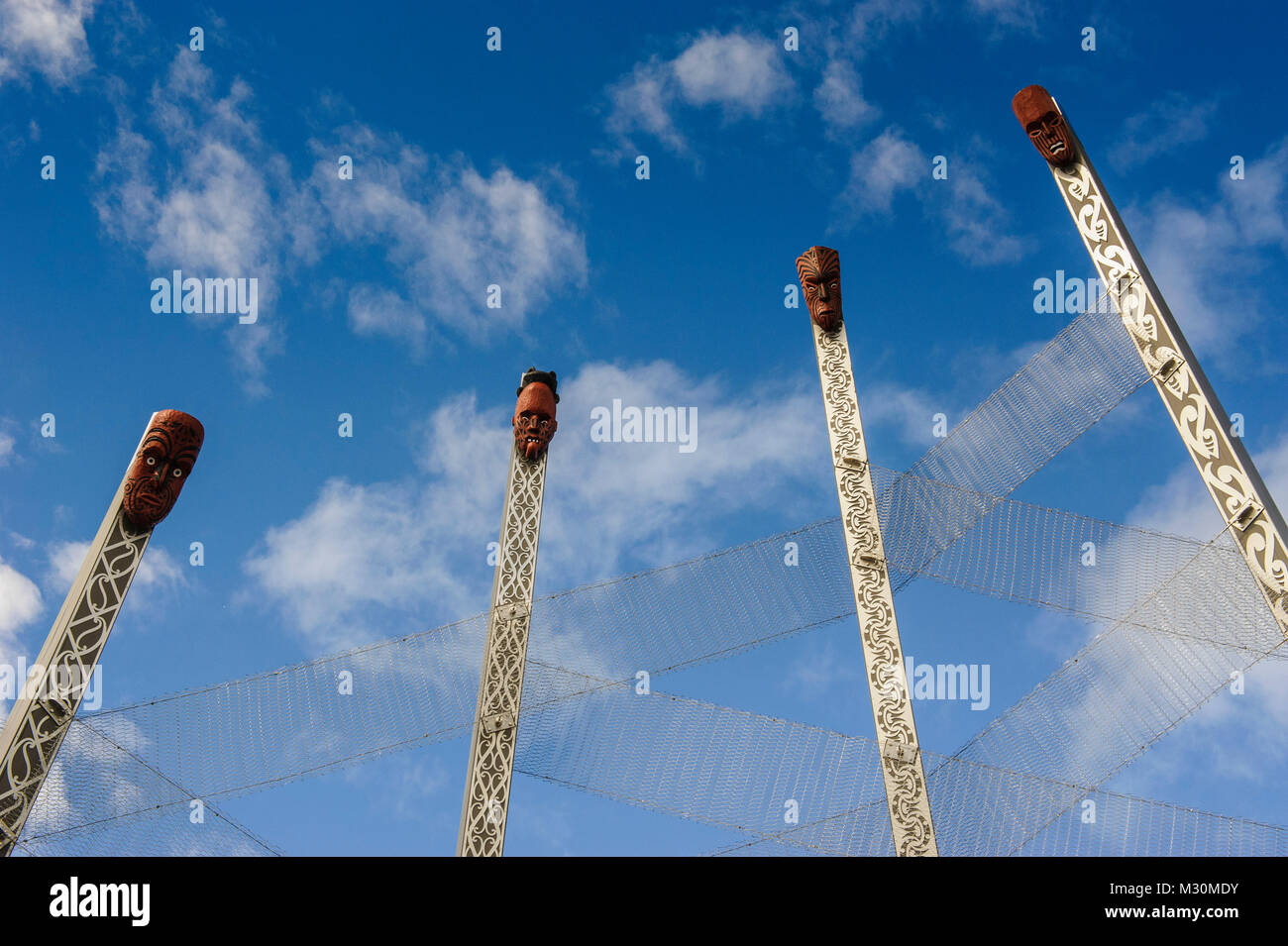 Intagliato a mano la maschera di legno a mucchi enormi al entranec di Te Puia Maori centro culturale, Roturura, Isola del nord, Nuova Zelanda Foto Stock