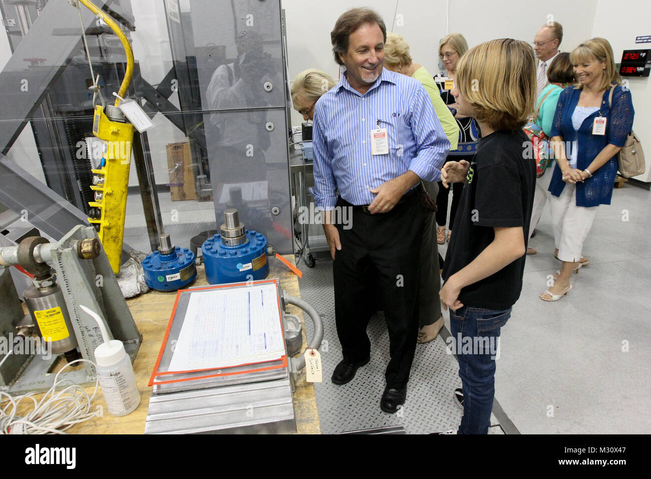 140528-N-HW977-166 NORCO, California (28 maggio 2014) Giovanni Lillywhite, sinistra , e suo figlio Giovanni Lillywhite Jr., reagiscono alla tecnologia sul display durante la visita di Norco/Eastvale rotante e cerchio rotante della città alla superficie navale Warfare Center (NSWC), Corona di divisione. Scopo della visita era quello di conoscere Rotariani locali con NSWC Corona ha la missione di sostenere il warfighter e stabilire connessioni locali per la fornitura di beni e servizi nonché di esplorare le opportunità di trasferire contribuente-finanziato la ricerca e la tecnologia per il settore privato. (U.S. Navy foto di Greg Vojtko/RILASCIATO) 140528-N-HW977-166 da NAVSEA Co Foto Stock