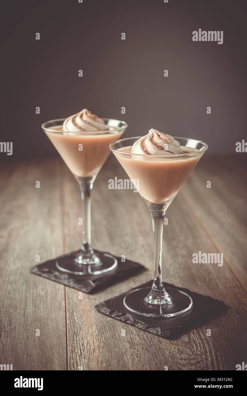 Due Irish cream liquori con un moto vorticoso della crema di latte Foto Stock