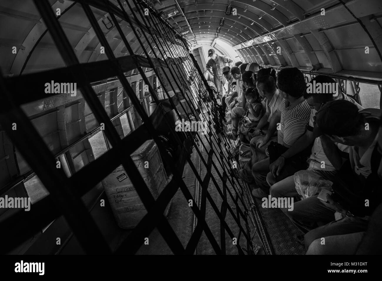 I passeggeri seduti in cabina, parzialmente caricato dal carico, in un Douglas DC-3 aeromobile prima di decollare in aeroporto di Villavicencio (Colombia). Foto Stock