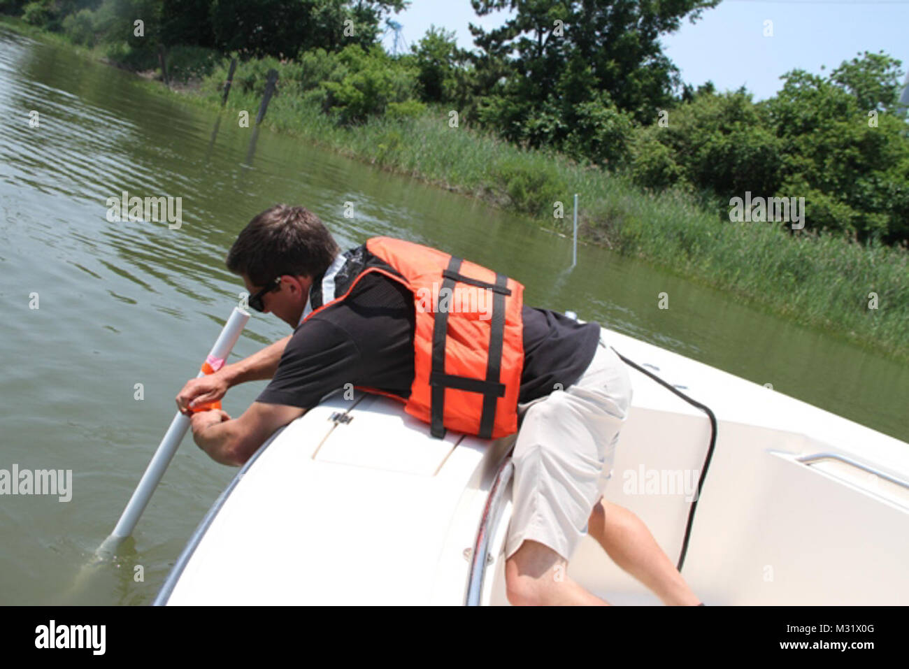 NORFOLK, Virginia (17 giugno 2014) - Keith Lockwood, Norfolk del distretto di Supporto Tecnico Capo sezione, segna un picchetto di confine di un nuovo oyster reef essendo inseminate con battibecco-su-guscio per consentire una più agevole sorveglianza del loro tasso di sopravvivenza. Lo scorso ottobre, Corps contraente Precon Marine Inc. di Chesapeake, Virginia, ha iniziato la fase due di un 10-anno, 70 milioni di dollari e 411 acri di mitigazione ambientale piano per compensare gli impatti ecologici associati con gli Stati Uniti Esercito di ingegnere Craney dell isola l'espansione verso Est, o CIEE, progetto. La fase due ha coinvolto la costruzione di sei santuario permanente Oyster Reef, totale Foto Stock