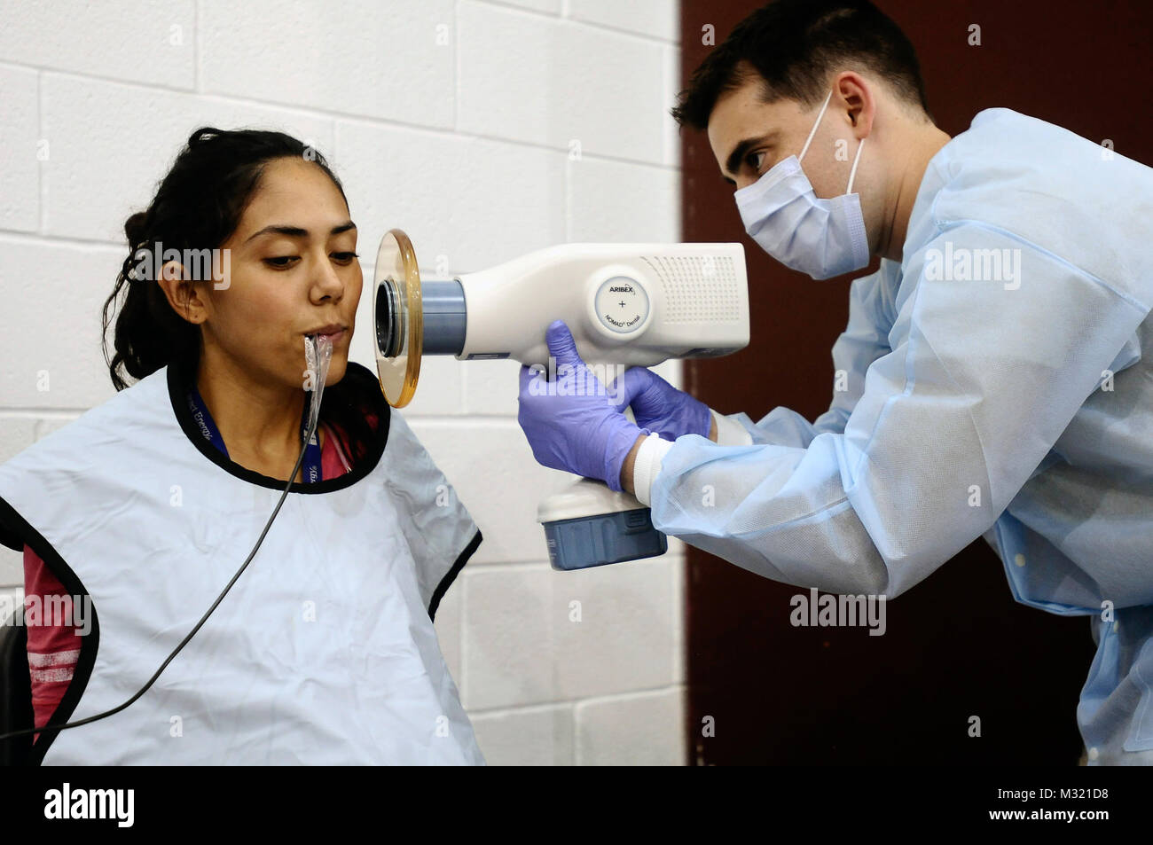 Texas Army National Guard Sgt. Ronald Birdwell del Texas Medical comando, Grand Prairie prende un X-ray di Maria Azucena Calderon prima che lei riceve un riempimento da servizi odontoiatrici forniti dal funzionamento Lonestar a Pharr-San Juan-Alamo High School in San Juan, Texas, 30 luglio 2013. Funzionamento Lone Star è un giro, bassa- a nessun costo dello screening medico e servizio di emergency readiness esercizio che è il più grande della sanità pubblica lo sforzo umanitario, del suo genere nel paese. L'esercizio eseguito simultaneamente in cinque siti lungo il sud del Texas area di confine di Brownsville, Texas, a Laredo, Texas, Foto Stock