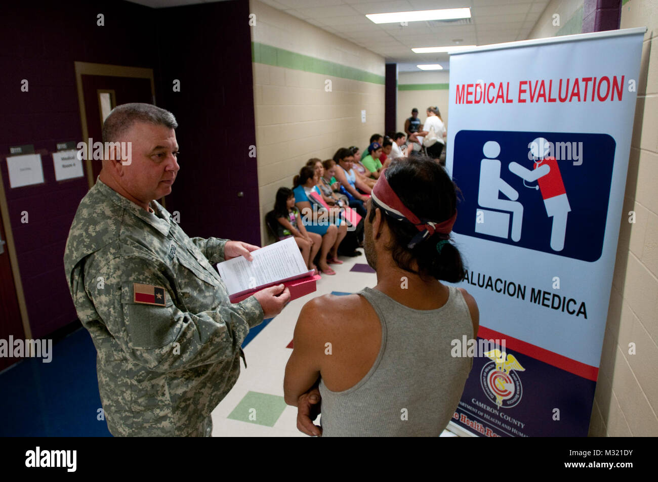 Sgt. William Alford, Tyler risposta medica Gruppo, Texas State Guard, assiste con il flusso dei pazienti attraverso Edward Manzano Jr. Middle School durante il funzionamento Lone Star in Brownsville, Texas, 31 luglio 2013. Funzionamento Lone Star serve come il solo accesso molti residenti nel Texas del Sud nella zona di confine hanno alle cure mediche o medici. Servizi disponibili inclusi immunizzazioni, diabetici e la pressione sanguigna proiezioni, ascolto e visione esami, sports physicals e servizi odontoiatrici. (U.S. Esercito nazionale Guard foto di esercito Spc. Aaron Moreno) 130730-Z-QF937-647 130730-Z-QF937-647 dai militari del Texas Foto Stock