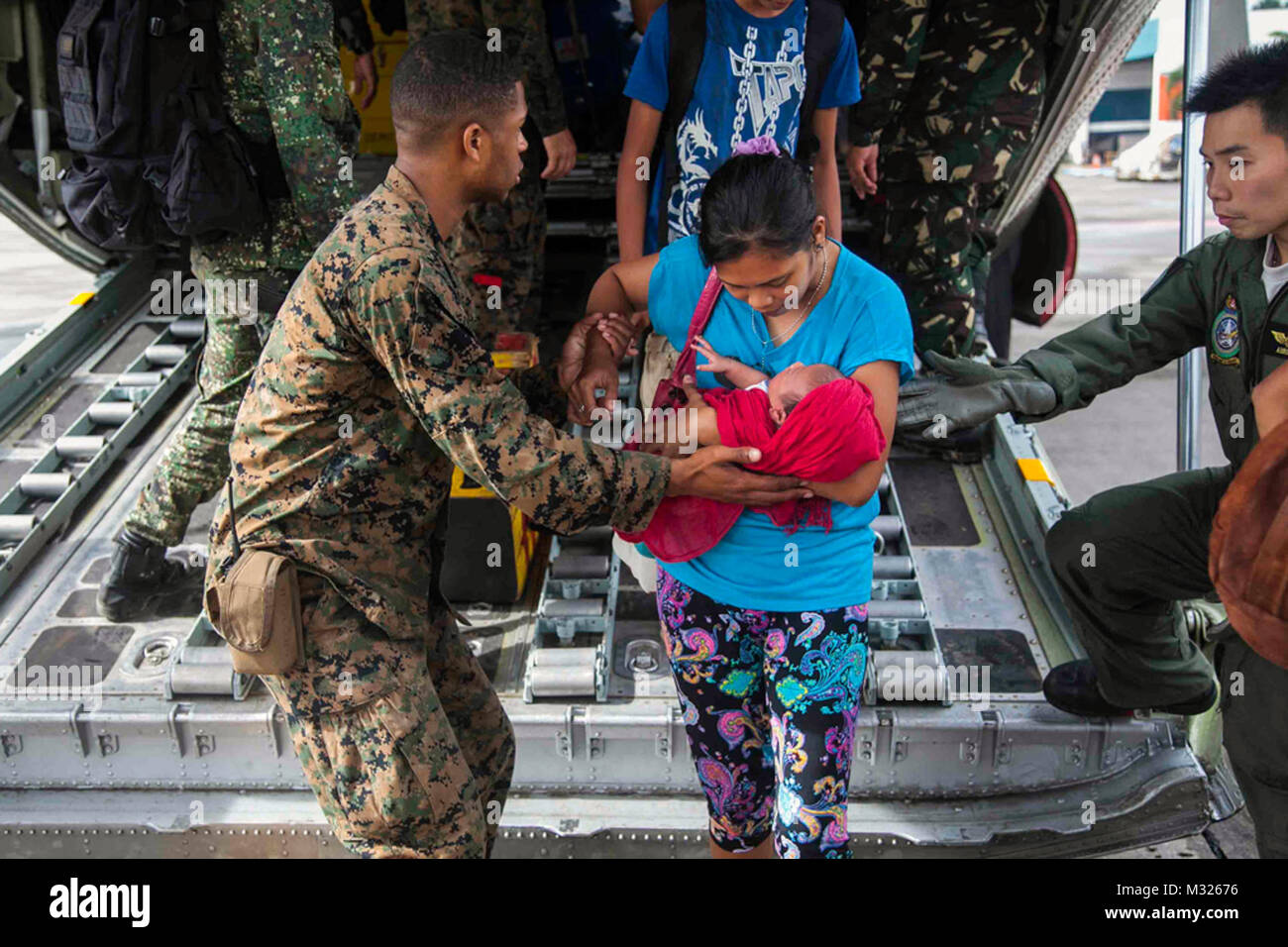 131112-M-GX379-618 Manila, Filippine (nov. 12, 2013) DEGLI STATI UNITI Lancia Marine Cpl. Xavier L. Cannon e membri del Philippine Forze Armate aiutare i civili sfollati dal tifone Haiyan sbarcare un velivolo C-130 a Villamor Air Base. Negli Stati Uniti i membri del servizio assistono le forze armate delle Filippine come essi preforma gli sforzi di recupero per le persone colpite nella scia del tifone Haiyan. (U.S. Marine Corps photo by Lance Cpl. Anne K. Henry/RILASCIATO) Noi Phi Forze Armate aiutare i civili sfollati dal tifone Haiyan da #PACOM Foto Stock