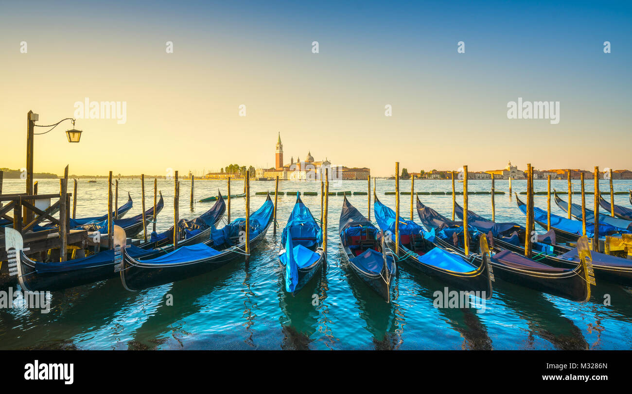 La laguna di Venezia al sunrise, chiesa di San Giorgio Maggiore, le gondole e i poli. L'Italia, l'Europa. Foto Stock