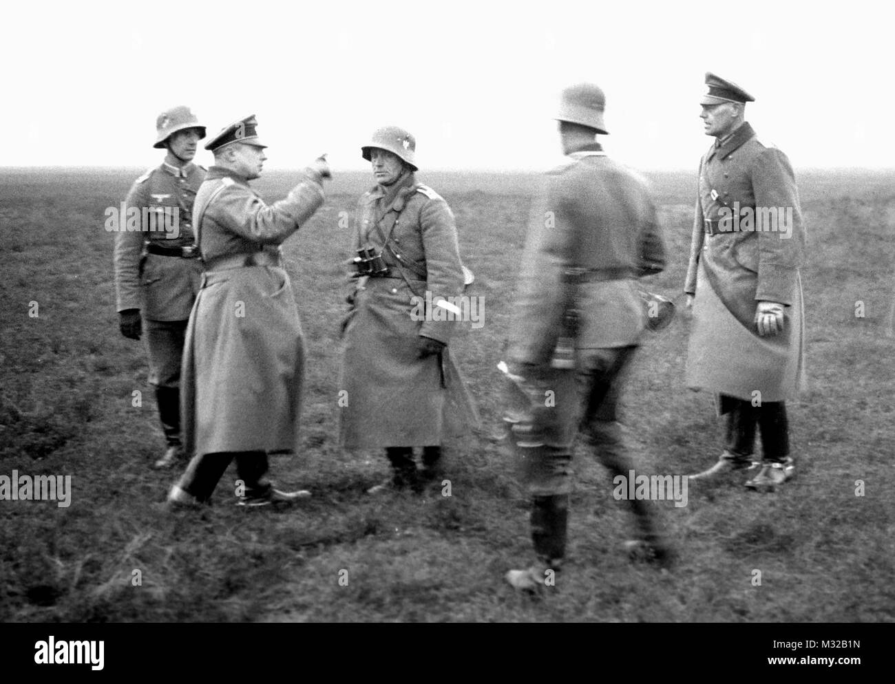 Un ufficiale tedesco sembra borato un soldato nel campo durante la seconda guerra mondiale, ca. 1938. Foto Stock