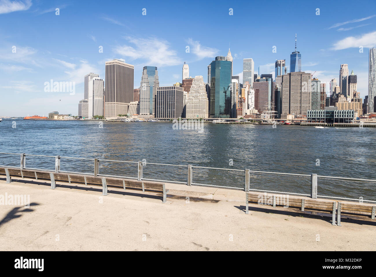 Il famoso lungofiume di Brooklyn con la Manhattan quartiere degli affari in background in tutta l'East River in New York City su un soleggiato da Foto Stock