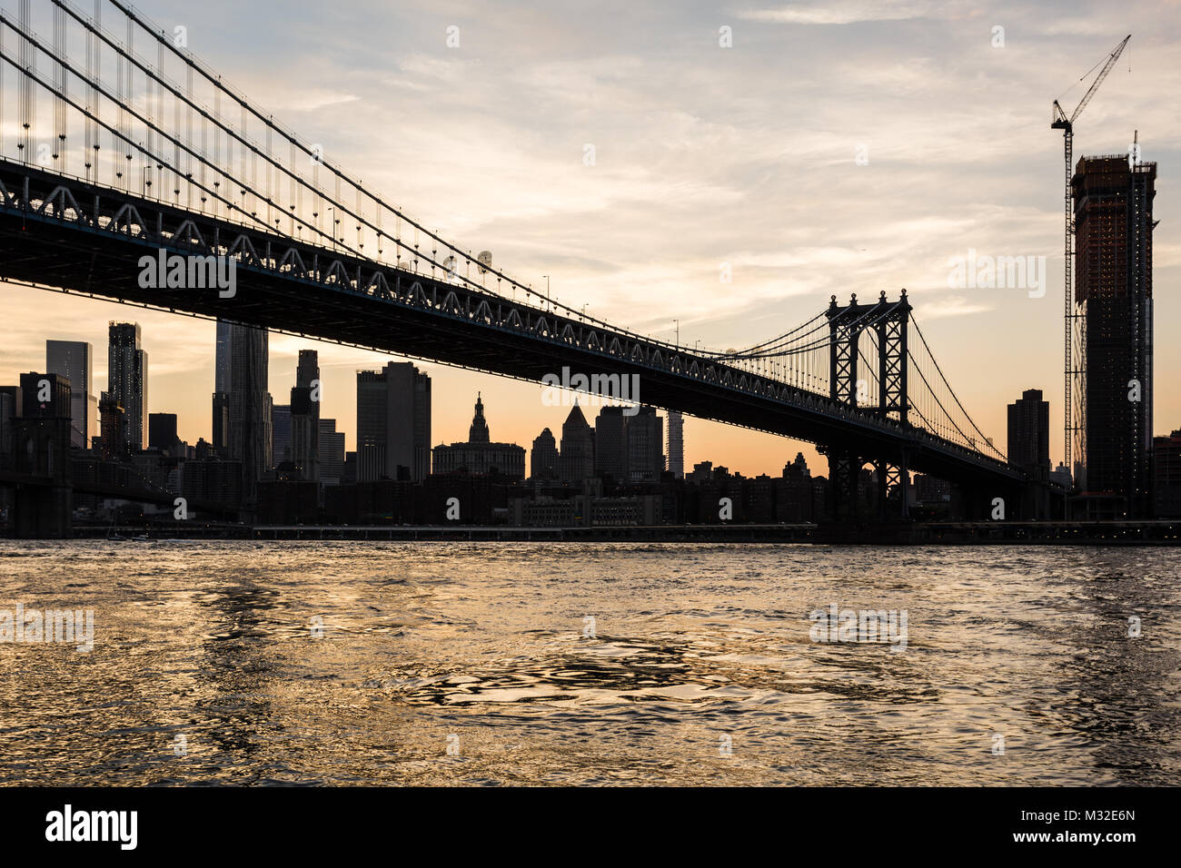 Tramonto mozzafiato su Manhattan Bridge e il Manhattan il quartiere finanziario in tutta l'East River da Brooklyn a New York City, Stati Uniti d'America Foto Stock