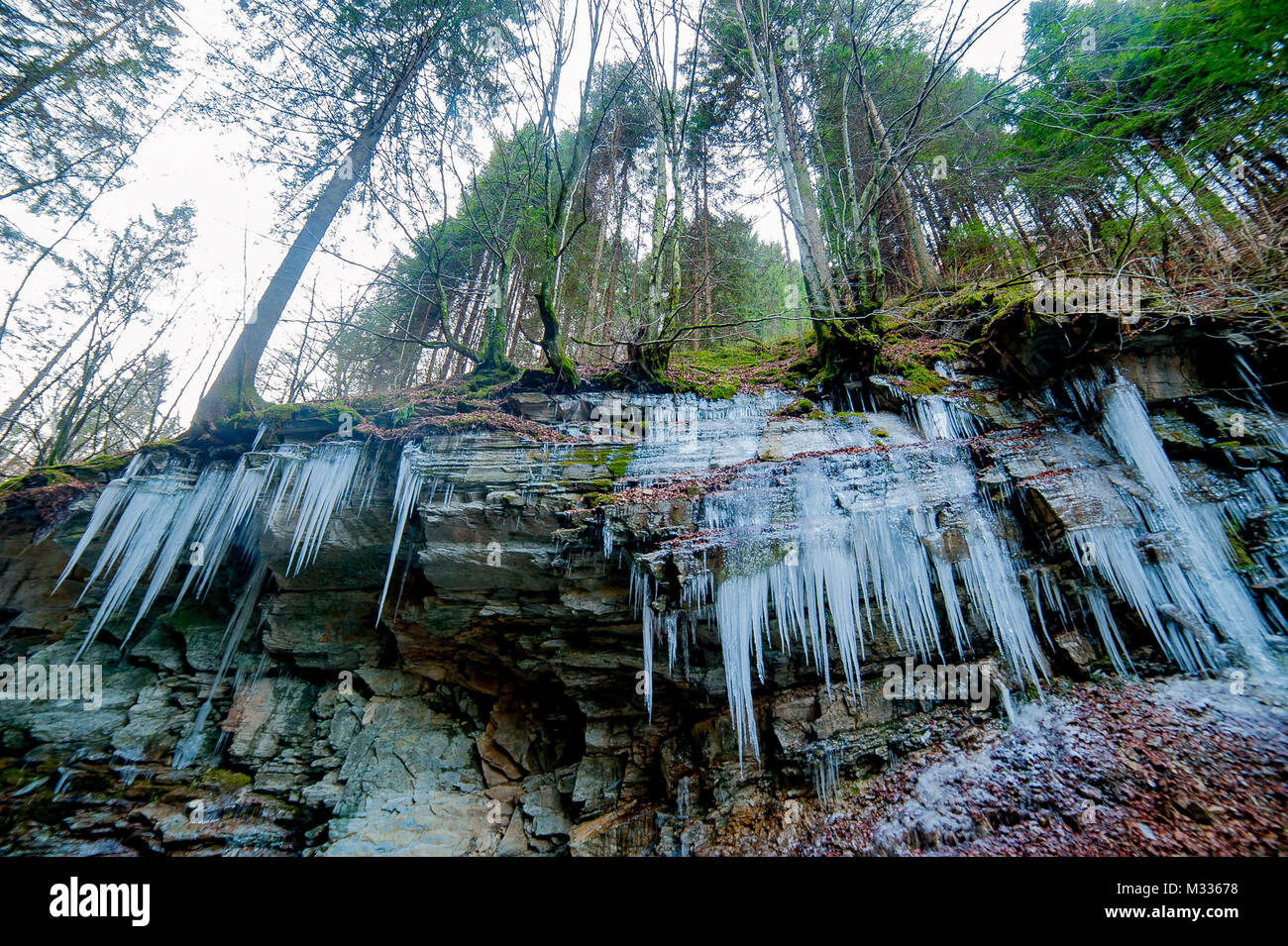 Icy rock con candele di ghiaccio Foto Stock