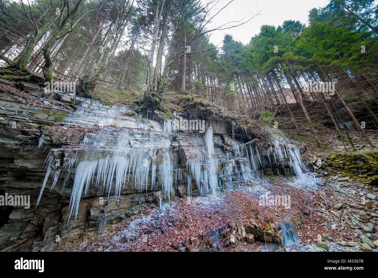 Icy rock con candele di ghiaccio Foto Stock