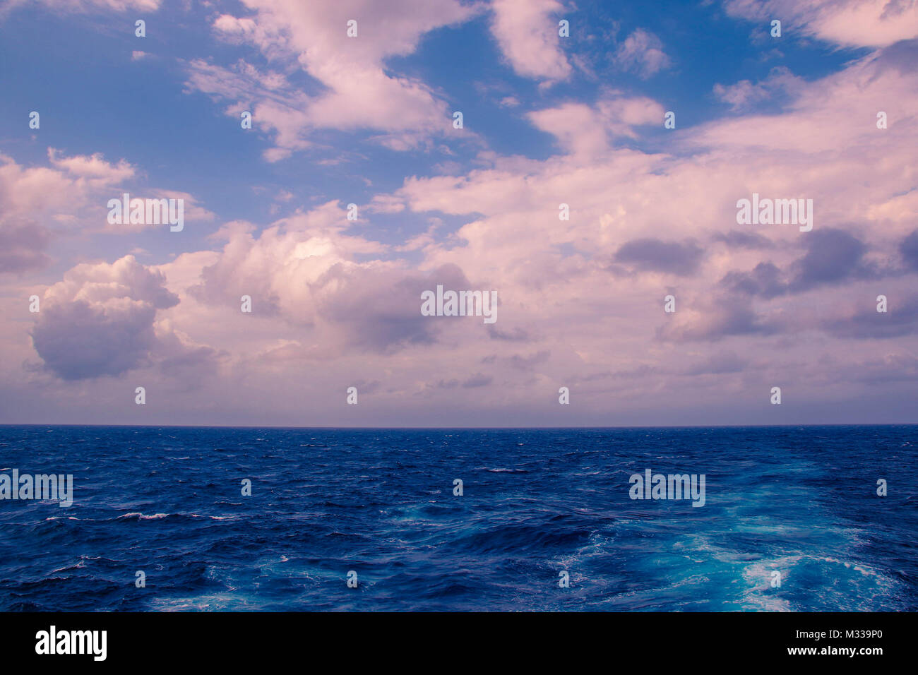 Tramonto sull'Oceano Meridionale al largo delle coste del Sud Africa su un nuvoloso, moody mattina, l'immagine in formato paesaggio con spazio di copia Foto Stock