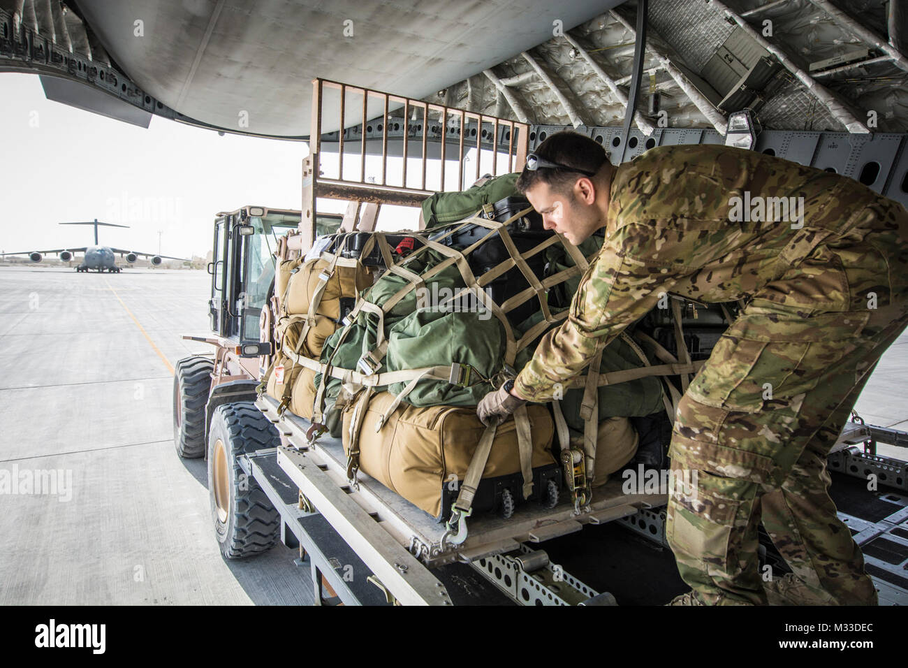 Stati Uniti Air Force Staff Sgt. Sam Hardy, loadmaster con il 816th Airlift Expeditionary Squadron, rotoli di un pallet di marcia su un C-17 Globemaster III at Al Udeid Air Base, Qatar, 25 gennaio, 2018. Il C-17 trasportato truppe ed equipaggiamenti per inoltrare le posizioni operative in tutti gli Stati Uniti Comando centrale area di responsabilità a sostegno della libertà di funzionamento la sentinella e la NATO la risoluta le missioni di sostegno. Il C-17 non solo è abile nel trasporto di truppe e cargo, ma possono eseguire tactical airlift e missioni di airdrop e trasporto pazienti ambulatoriali durante le evacuazioni di medicina aeronautica. (U.S. Aria Nat Foto Stock