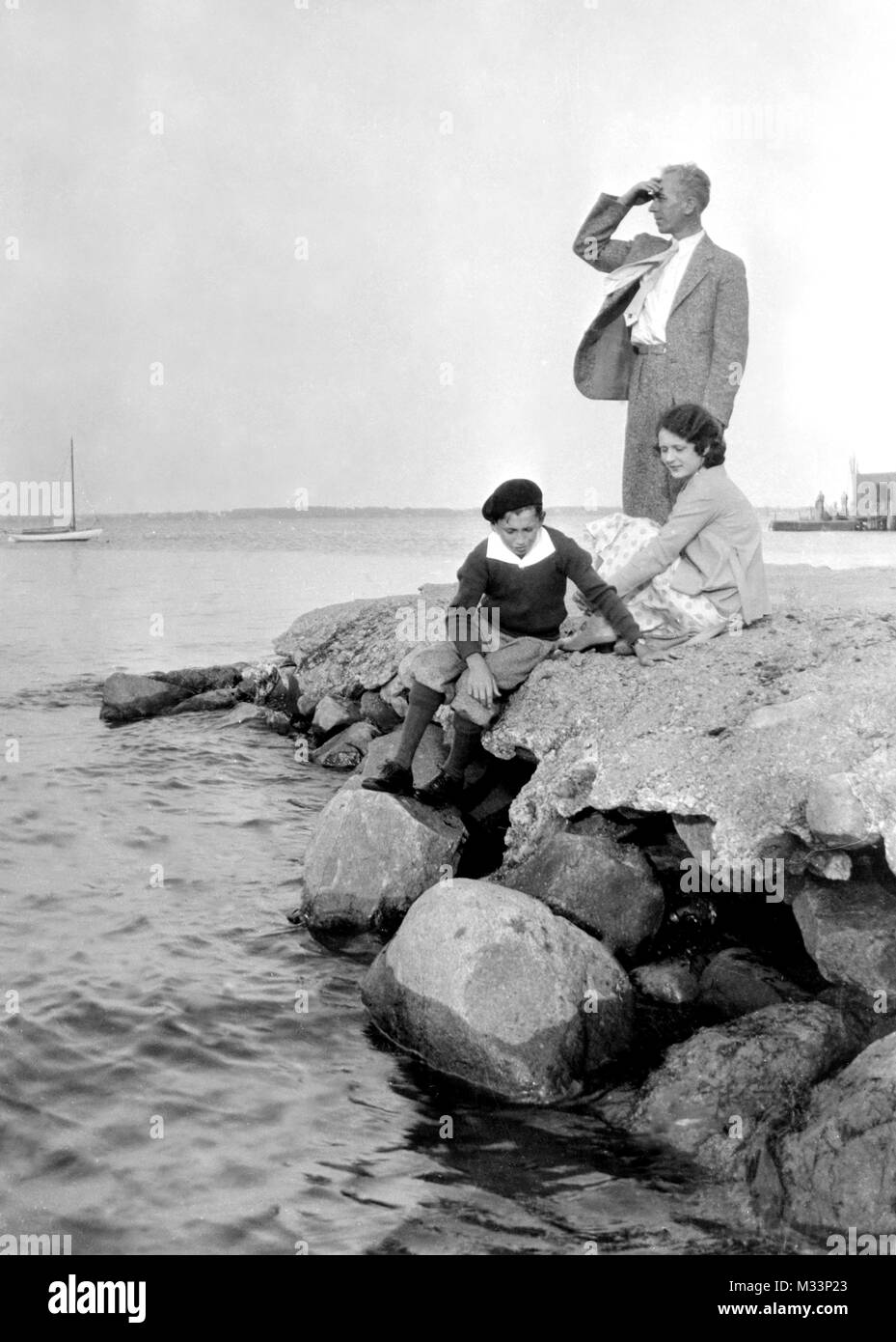 Una coppia e il loro figlio stand su alcune rocce in Nova Scotia, ca. 1930. Foto Stock