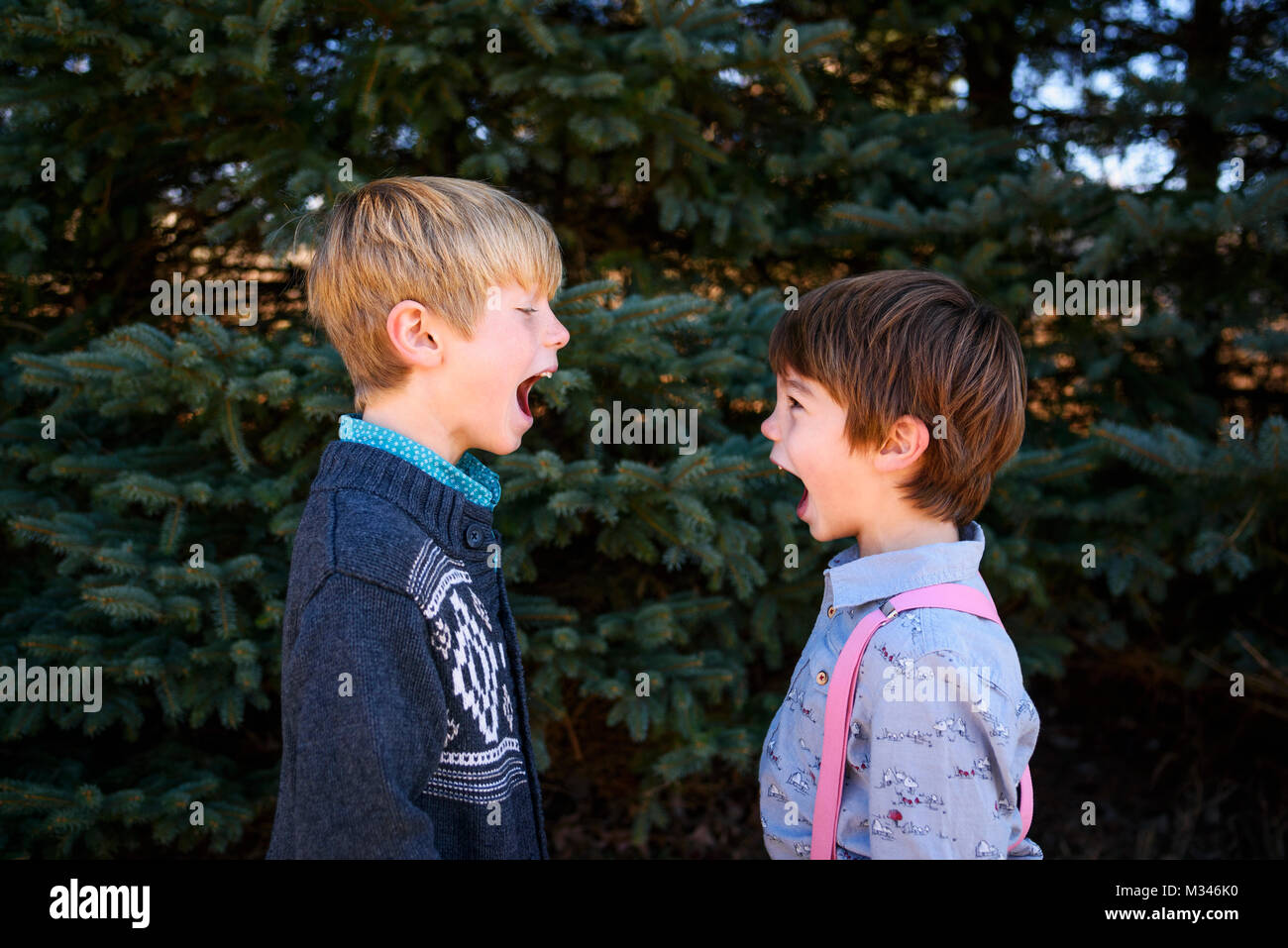 Due ragazzi in piedi di fronte a ogni altro con la bocca aperta Foto Stock