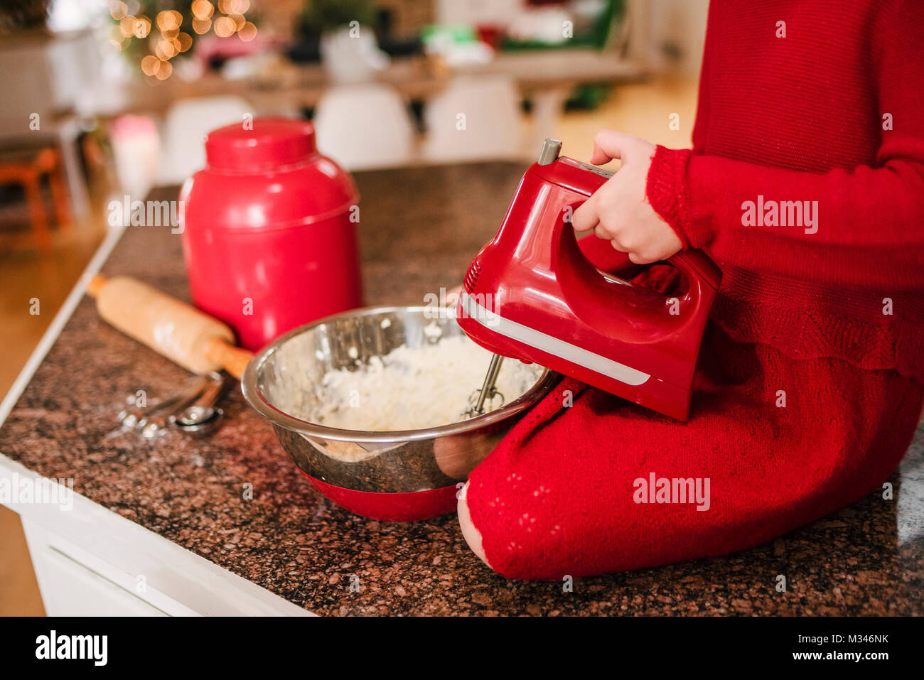 Ragazza seduta su un bancone cucina top facendo biscotti di Natale Foto Stock