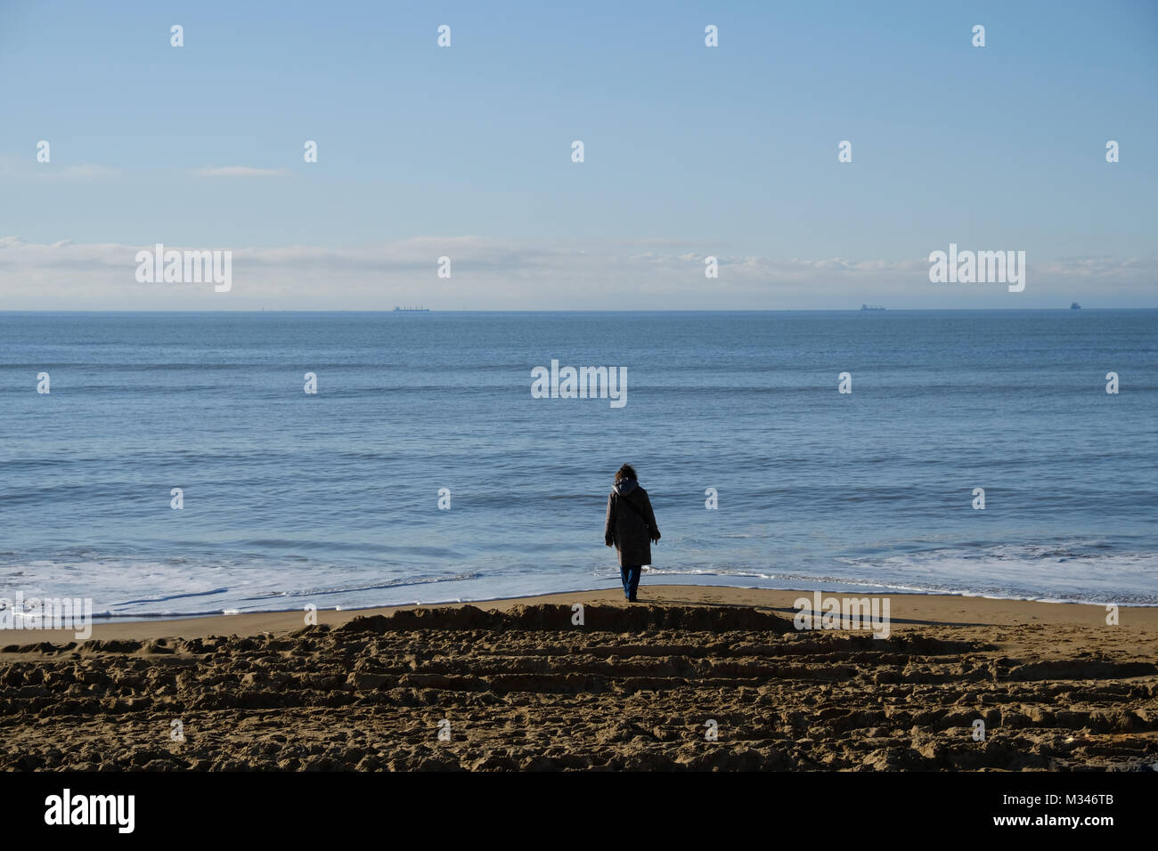 Donna in piedi sulla spiaggia, Chatelaillon, La Rochelle, Nouvelle-Aquitaine, Francia Foto Stock