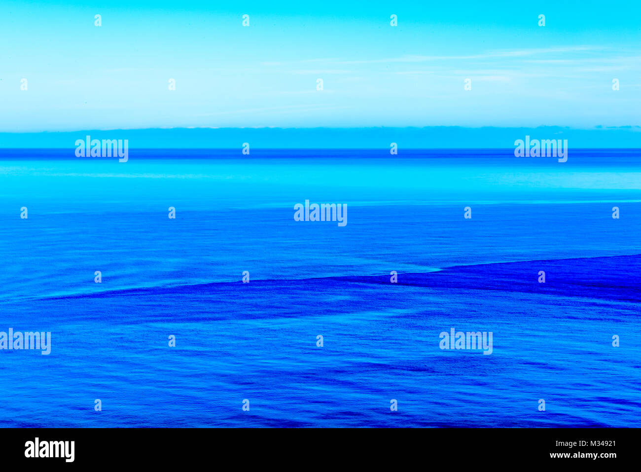 Stilizzata una lunga esposizione sunset seascape con diverse sfumature di blu ha montrato come arte astratta immagine. Foto Stock