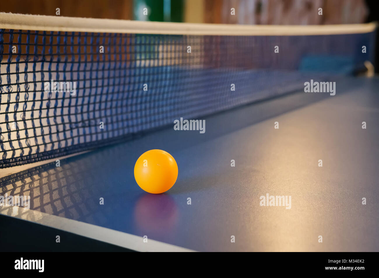 Tabella arancione palla da tennis sul tavolo blu con net Foto Stock