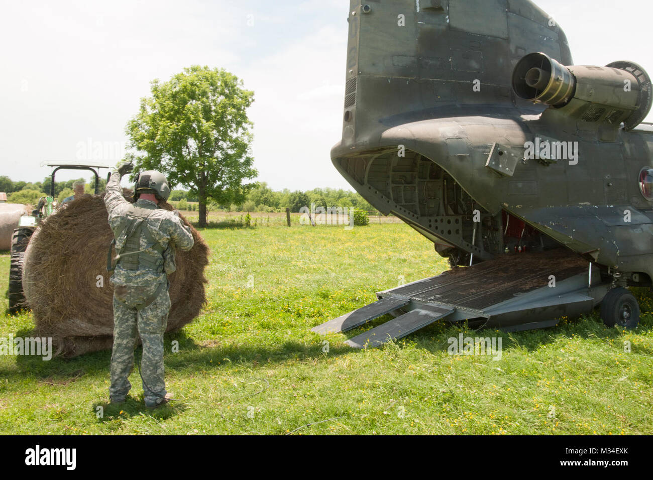 I membri della società B, 2° Battaglione, 149Aviazione Generale del battaglione di supporto, Oklahoma, l esercito nazionale Guard, che gestiva il CH-47 'Chinook elicottero", assistito un cowboy nella contea di Muskogee il 27 maggio 2015, dopo le acque di esondazione stranded oltre 100 vacche senza cibo. Il Chinook's equipaggio consegnati più di 10.000 libbre di fieno e mangimi per il bestiame a filamento durante lo stato di active duty missione. Foto: Il Mag. Geoff Legler, Oklahoma Guardia Nazionale degli affari pubblici caduta di fieno 012 da Oklahoma Guardia Nazionale Foto Stock