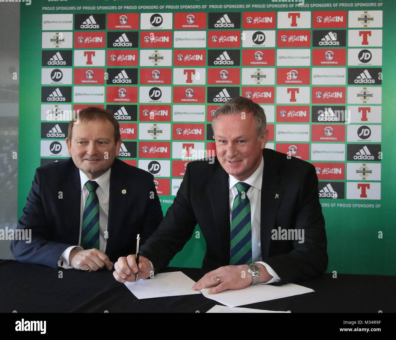 Belfast, Regno Unito. Il 9 febbraio, 2018. Stadio Nazionale al Windsor Park di Belfast, Irlanda del Nord. La Irish Football Association oggi formalmente annunciato che l'Irlanda del Nord manager Michael O'Neill aveva firmato un mandato di quattro anni di estensione del contratto. Michael O'Neill (a destra) pone la penna con Irish Football Association il Presidente David Martin accanto a lui. Credito: David Hunter/Alamy Live News. Foto Stock