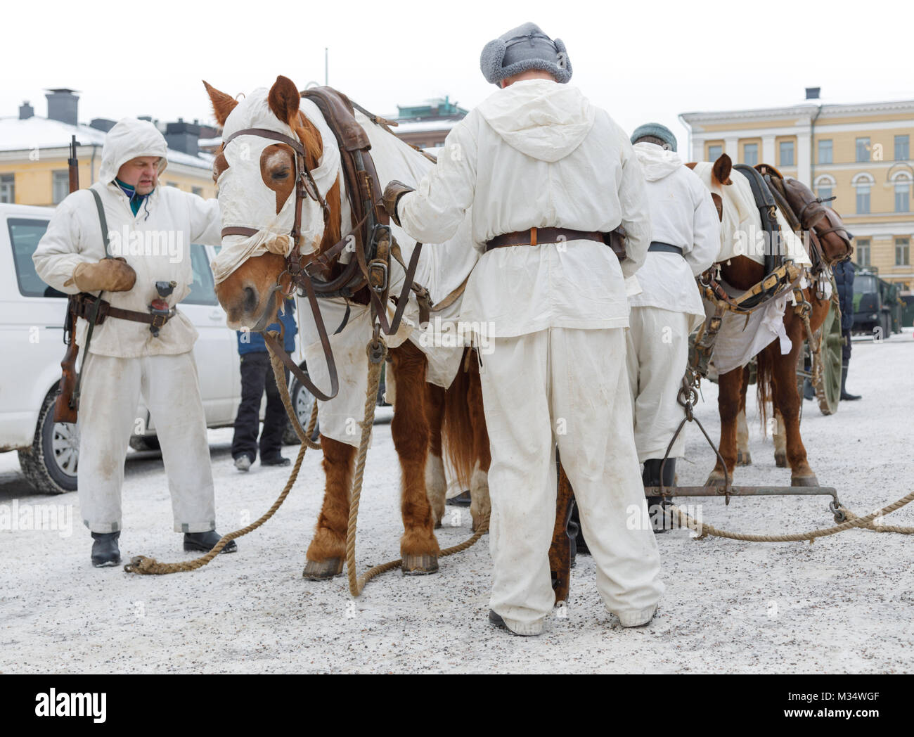Helsinki, Finlandia. 8 febbraio, 2018. Per commemorare i cento anni di storia di artiglieria indipendente in Finlandia, un evento pubblico è stato disposto in corrispondenza della Piazza del Senato di Helsinki il 9 febbraio 2018. Vi è stato un display delle attuali attrezzature, oltre la rievocazione di un cavallo-pilotato campo pezzo di artiglieria guidato in una posizione di lancio. I cavalli come pure la cottura equipaggio di indossare il bianco della neve camouflage, come nei giorni della guerra d'inverno 1939-40. Credito: Hannu Mononen/Alamy Live News Foto Stock