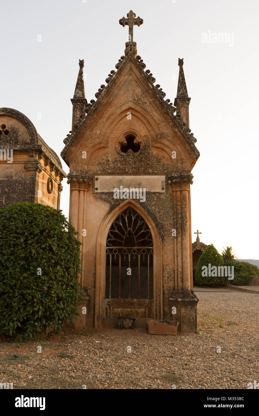 Il mausoleo fatto di locali di colore arancione pallido pietra in Roussillon Francia. La costruzione è sormontata da una croce scolpita e guglie. Un sentiero di ghiaia è in Foto Stock Il mausoleo fatto di locali di colore arancione pallido pietra in Roussillon Francia. La costruzione è sormontata da una croce scolpita e guglie. Un sentiero di ghiaia è in Foto Stock