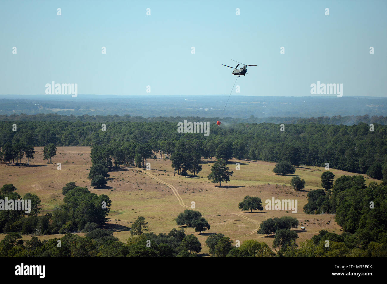 Un esercito di Texas National Guard CH-47 Chinook da Grand Prairie assiste nel sopprimere un wildfire in Bastrop County, Texas. Il Texas National Guard per mobilitare le risorse di aviazione da Austin, Grand Prairie e San Antonio per contribuire a combattere il fuoco che bruciò circa 4.200 acri e distrutto quasi una decina di case. (Air National Guard foto da 1Lt. Alicia Lacy/RILASCIATO) 151015-Z-NC104-070 da Texas Dipartimento Militare Foto Stock