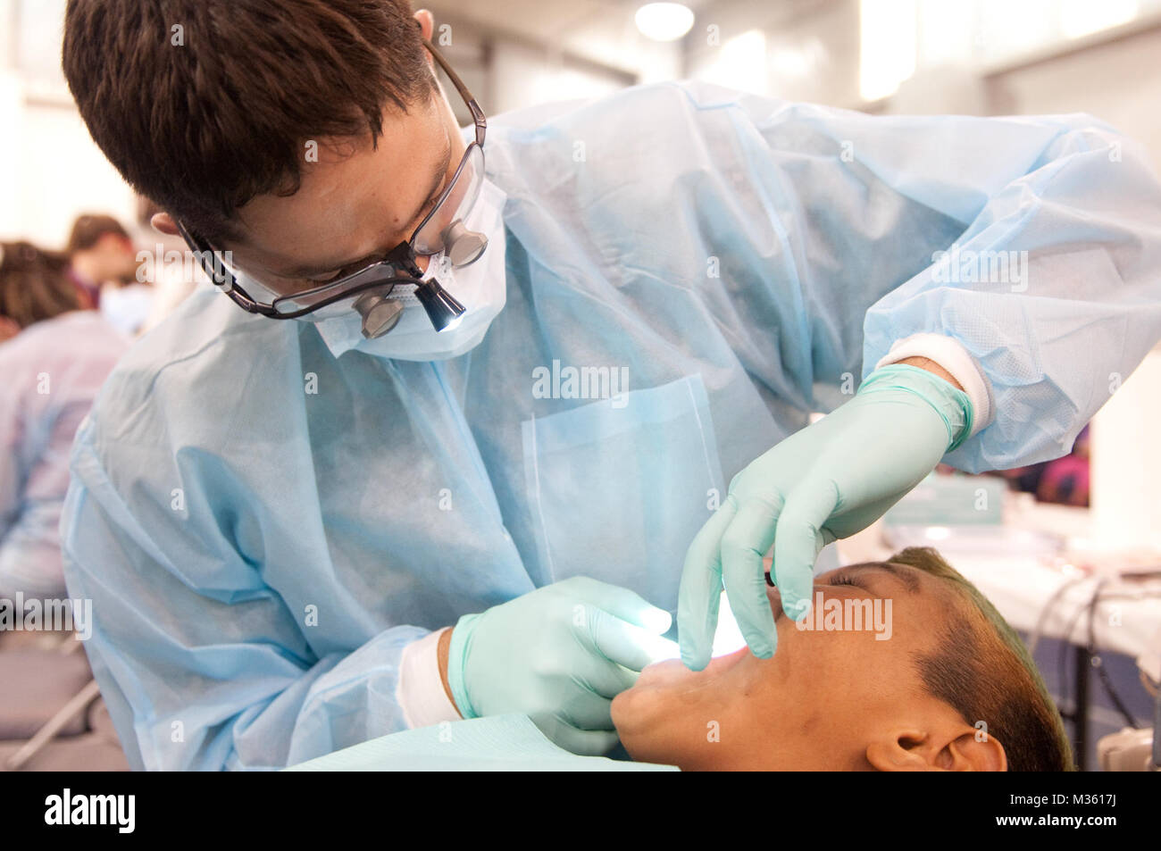 Il cap. Tyler Torres, un dentista con Texas Medical comando, Texas Army National Guard, esamina un paziente per le cavità durante il funzionamento Lone Star in San Juan, Texas, 29 luglio 2015. OLS è un corso di cinque giorni mass casualty, la preparazione alle situazioni di emergenza e esercizio nel sud del Texas, che dà il Texas guardie e gli enti locali e stato di salute agenzie la possibilità di trattare i pazienti civili e rimangono pronti per una vera catastrofe mondiale. (Texas Guardia Nazionale foto di esercito Sgt. Praxdis Piñeda) 2015 Funzionamento Lone Star da Texas Dipartimento Militare Foto Stock