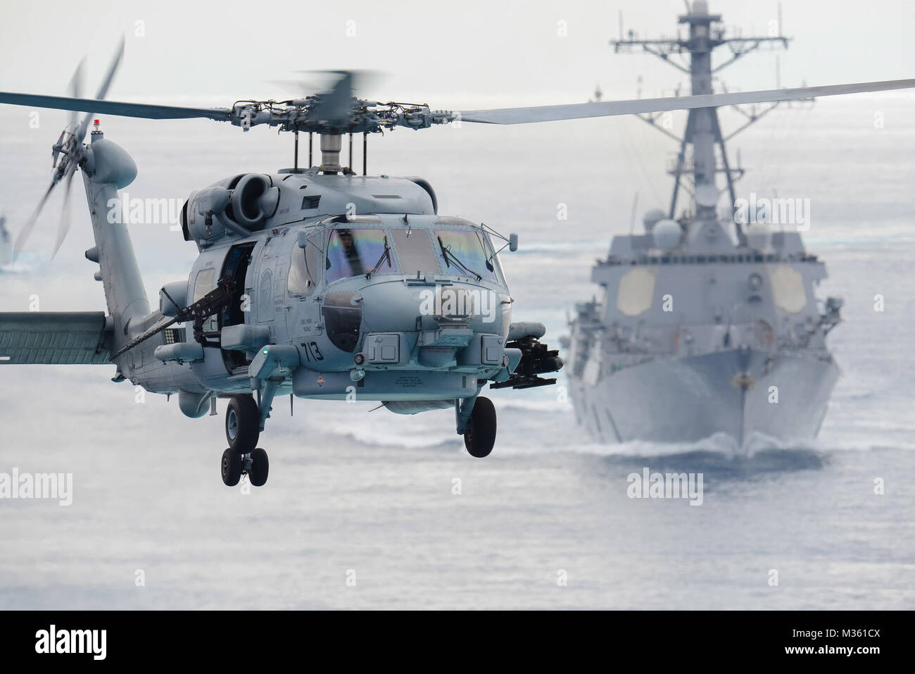 150811-N-XX566-010 OCEANO PACIFICO (Agosto 11, 2015) un MH-60R Sea Hawk elicottero assegnato ai rapaci di elicottero Maritime Strike Squadron (HSM) 71 si prepara a terra a bordo della portaerei USS John C. Stennis (CVN 74) come guidato-missile destroyer USS Chung Hoon (DDG 93) segue dietro durante una prova di forza di transito. John C. Stennis Strike gruppo sta subendo un composito di unità per la formazione di esercizio e di joint task force esercizio, il passo finale nella certificazione di distribuire. (U.S. Foto di Marina di Massa lo specialista di comunicazione di terza classe Andre T. Richard/RILASCIATO) MH-60R Sea Hawk elicottero Pre Foto Stock