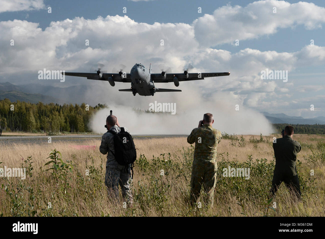 Gli osservatori di guardare un C-130 Hercules con la trentaseiesima Airlift Squadron da Yokota Air Base, Giappone, decollo di un austero pista utilizzata per la formazione durante la bandiera rossa-Alaska a base comune Elmendorf-Richardson, Alaska, 14 agosto 2015. La formazione ha permesso C-130 equipaggi alla pratica austera gli sbarchi e take offs, offload di combattimento e alimentazione gocce, ma ha anche consentito una competizione amichevole tra partecipanti forze dell'aria: U.S. Air Force, Giappone Aria forza di autodifesa, Royal Air Force, Royal Australian Air Force, Royal New Zealand Air Force e il Royal Thai Air Force. Condito C-130 equipaggi da ciascun paese giudicato Foto Stock