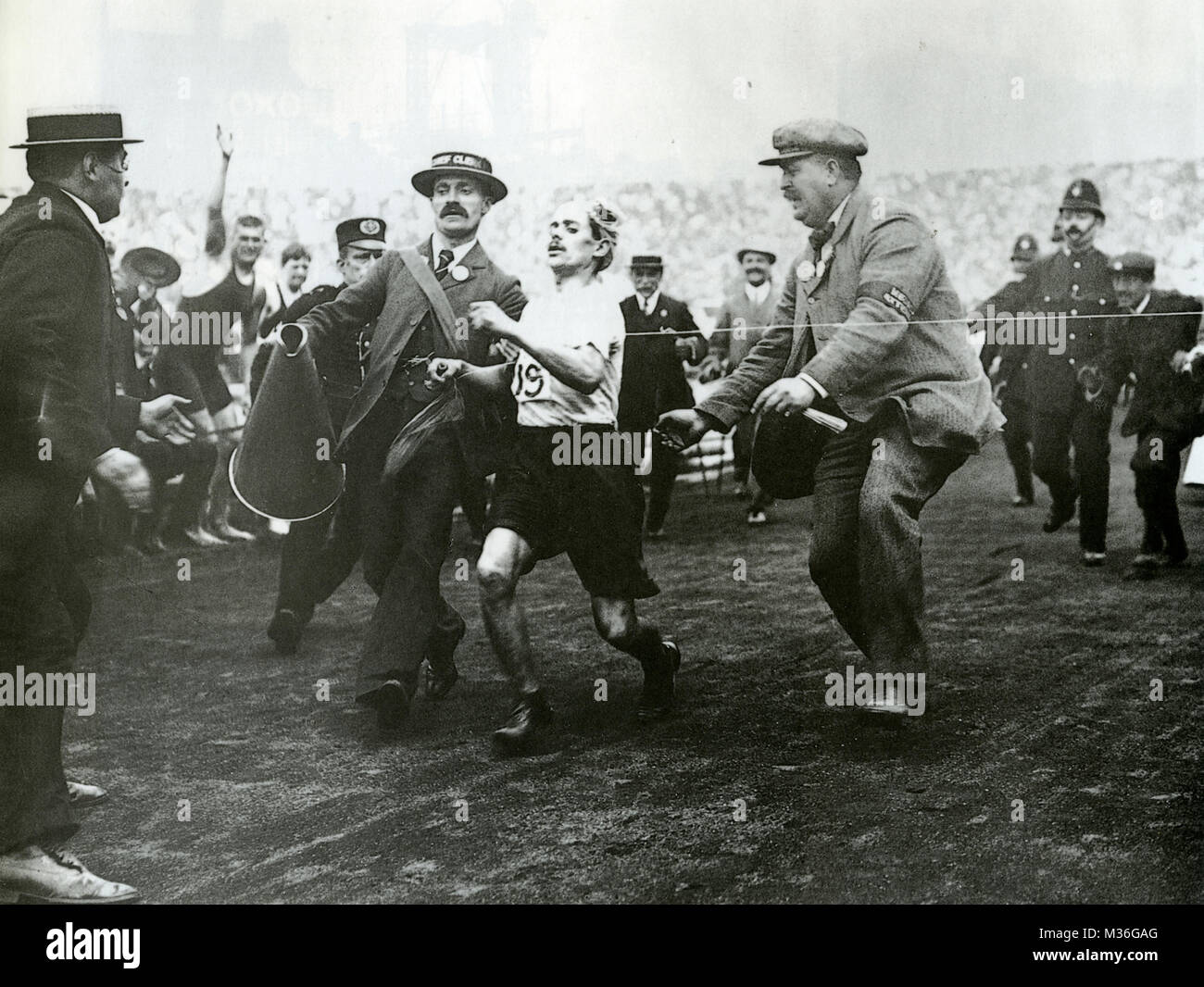 DORANDO PIETRI (1885-1942) italiani a lunga distanza runner al traguardo del 1908 Olympics Marathon aiutato dal dottor Michael Bulger a destra. Foto Stock