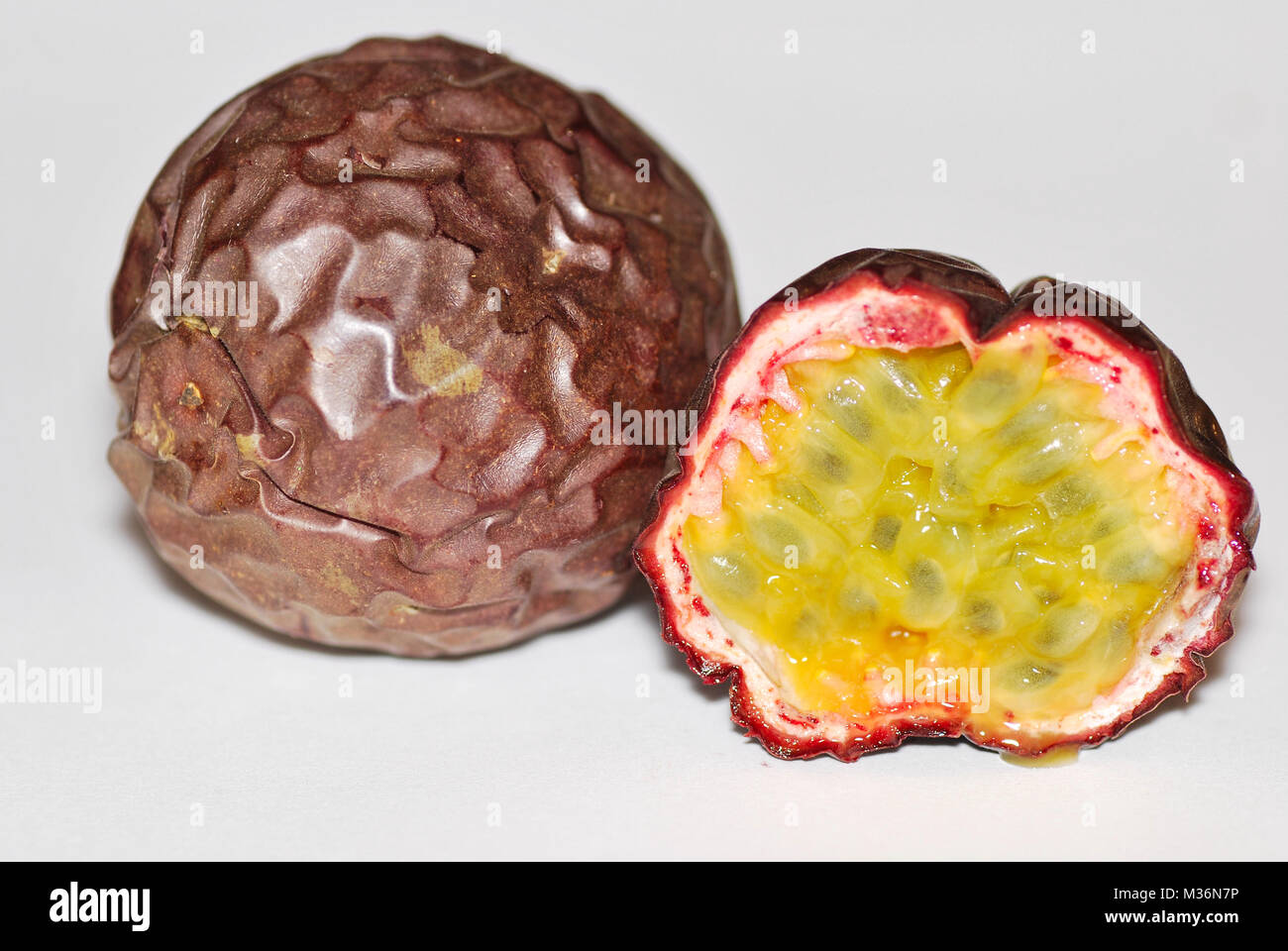 Il frutto della passione di un intero e nella parte anteriore di un mezzo taglio Foto Stock