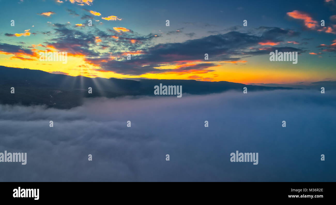 Vista aerea. Volare sopra le nuvole . Antenna di ripresa della telecamera. Durante il tramonto. Panorama del paesaggio. Foto Stock