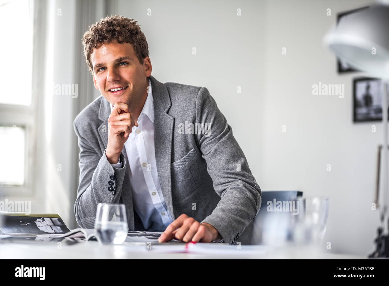 Ritratto di fiducioso giovane imprenditore lavora in ufficio tabella Foto Stock