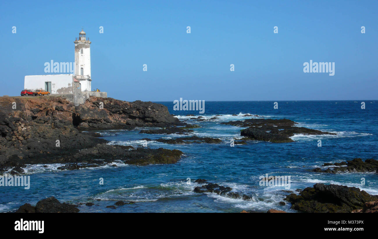 Faro bianco su un rocky point sull'Oceano Atlantico nelle isole del Capo Verde su Santiago vicino a Praia Foto Stock