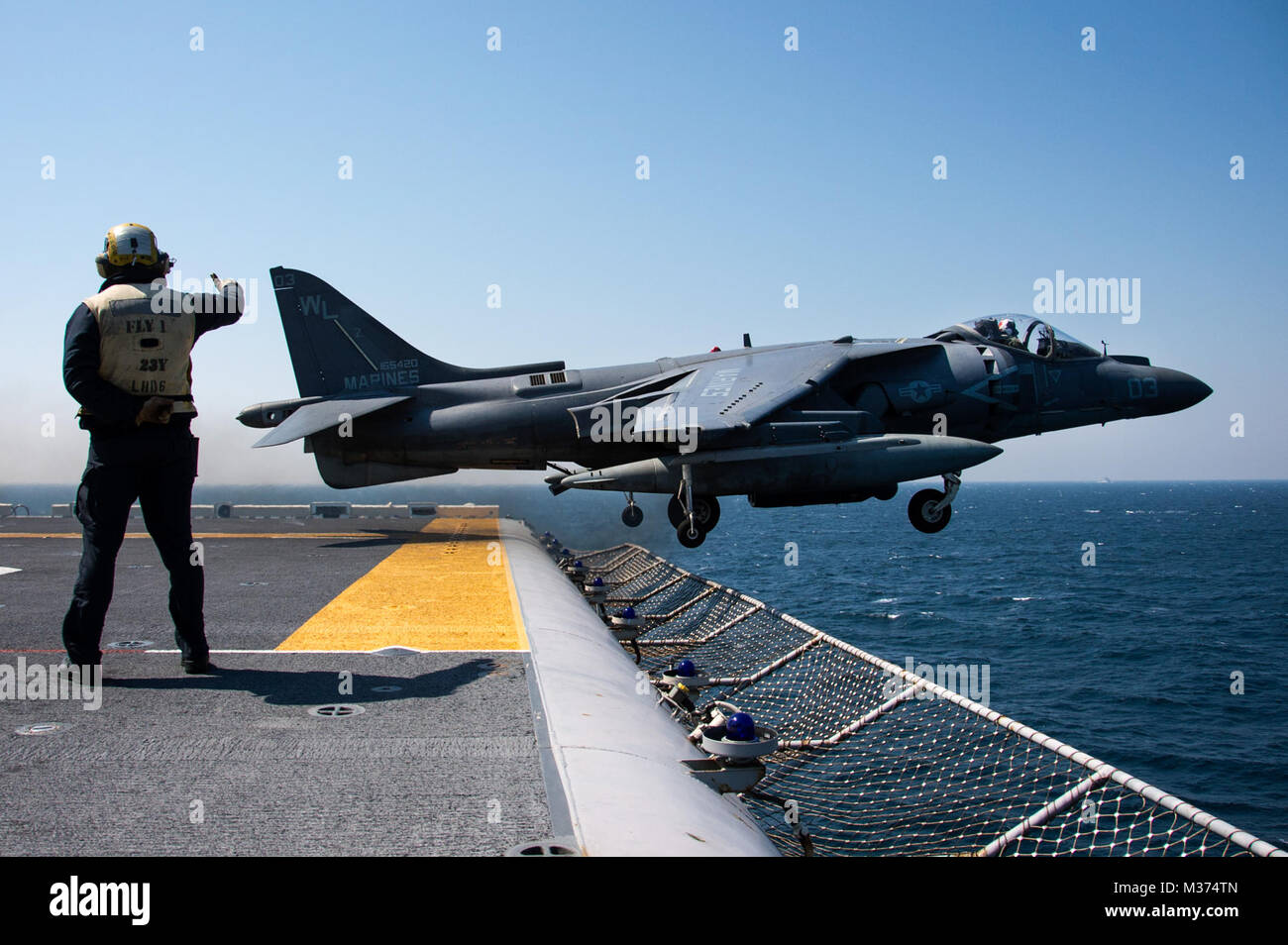 170403-N-WF272-554 Mar Cinese orientale (3 aprile 2017) dell'aviazione di Boatswain Mate (manipolazione) Airman Matteo Tito, da St. Louis, Mo., dirige il lancio di un AV-8B Harrier, assegnato al Tomcats di attacco Marino Squadron (VMA) 311, dal ponte di volo dell'assalto anfibio nave USS Bonhomme Richard (LHD 6). Bonhomme Richard, ammiraglia del Bonhomme Richard Expeditionary Strike gruppo, con avviato 31 Marine Expeditionary Unit, è su una pattuglia di routine, operando in Indo-Asia-regione del Pacifico per migliorare la prontezza combattimento e la postura in avanti come una pronta risposta in vigore per qualsiasi tipo di c Foto Stock