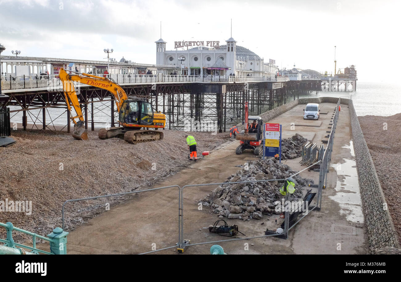 Escavatori a lavorare sulla difesa del mare inguine accanto al Palace Pier Brighton Regno Unito Foto Stock