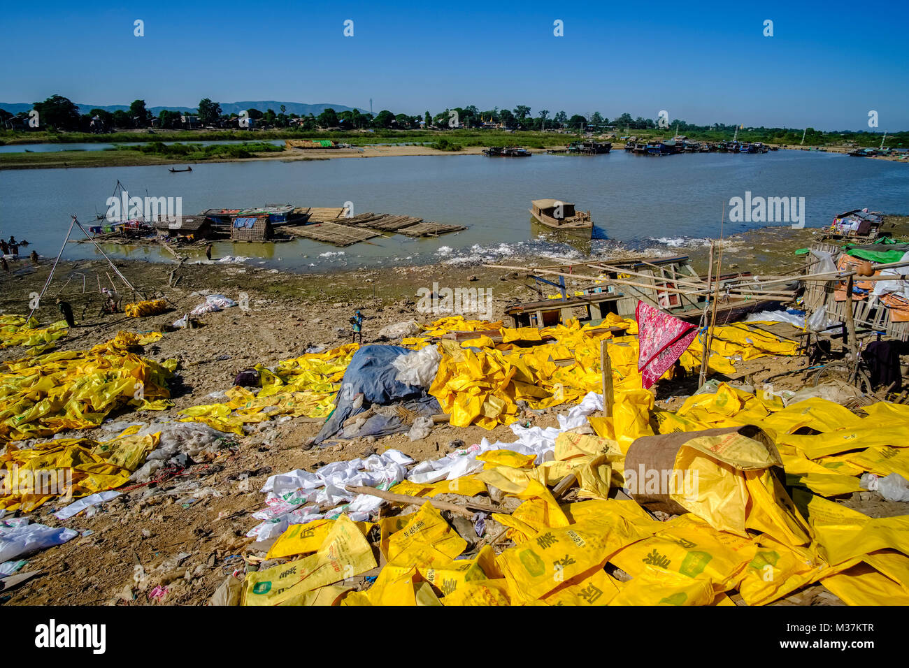 Sacchetti di plastica vengono riciclati alla periferia della città nei pressi del fiume Irrawaddy Foto Stock