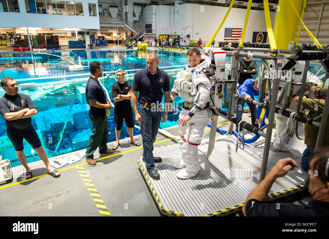 Agenzia Spaziale Canadese astronauta David Saint Jacques aiuta l'Astronauta Col. Tyler N. "Nick" Aia prepararsi ad essere abbassata in una piscina con un mockup della Stazione Spaziale Internazionale (ISS) per attività Extravehicular (EVA) di formazione presso il Johnson Space Flight Center la galleggiabilità neutra di laboratorio (NBL) a Houston, Tex., apr. 27, 2017. Durante il corso di formazione a NBL, Aia indossa una tuta spaziale per simulare il vicino ambiente eterea che incontrerà durante l'esecuzione di Eva, o i viaggi futuri, mentre serve come un tecnico di volo sulla spedizione 54/55 a bordo della ISS nel 2018-2019. (U.S. Air Force foto di J.M. Eddins Jr Foto Stock