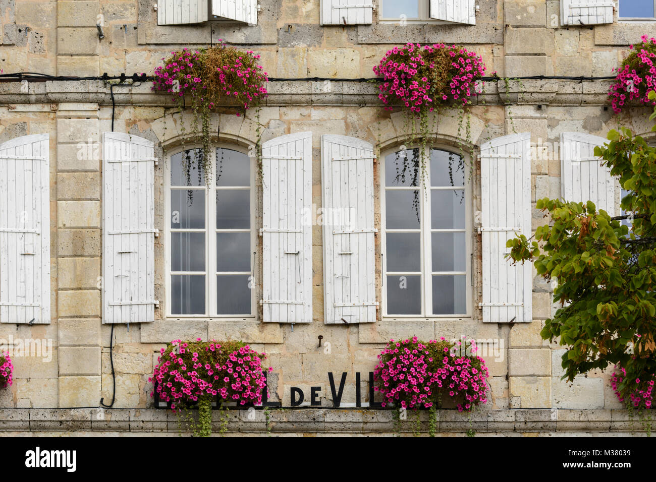 Persiane alle finestre e fiori del Municipio (Mairie / Hotel de Ville) in Montréal-du-Gers (Montreal du Gers), Gers (Guascogna), Occitanie, Francia Foto Stock