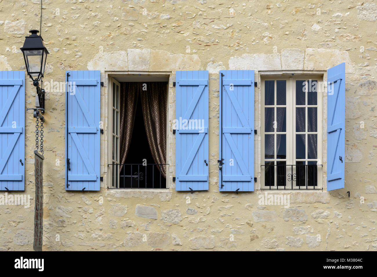 Close up di finestre con persiane in legno di colore blu su un edificio in Montréal-du-Gers (Montreal du Gers), Gers (Guascogna), Occitanie (Midi-Pyrénées), Francia Foto Stock