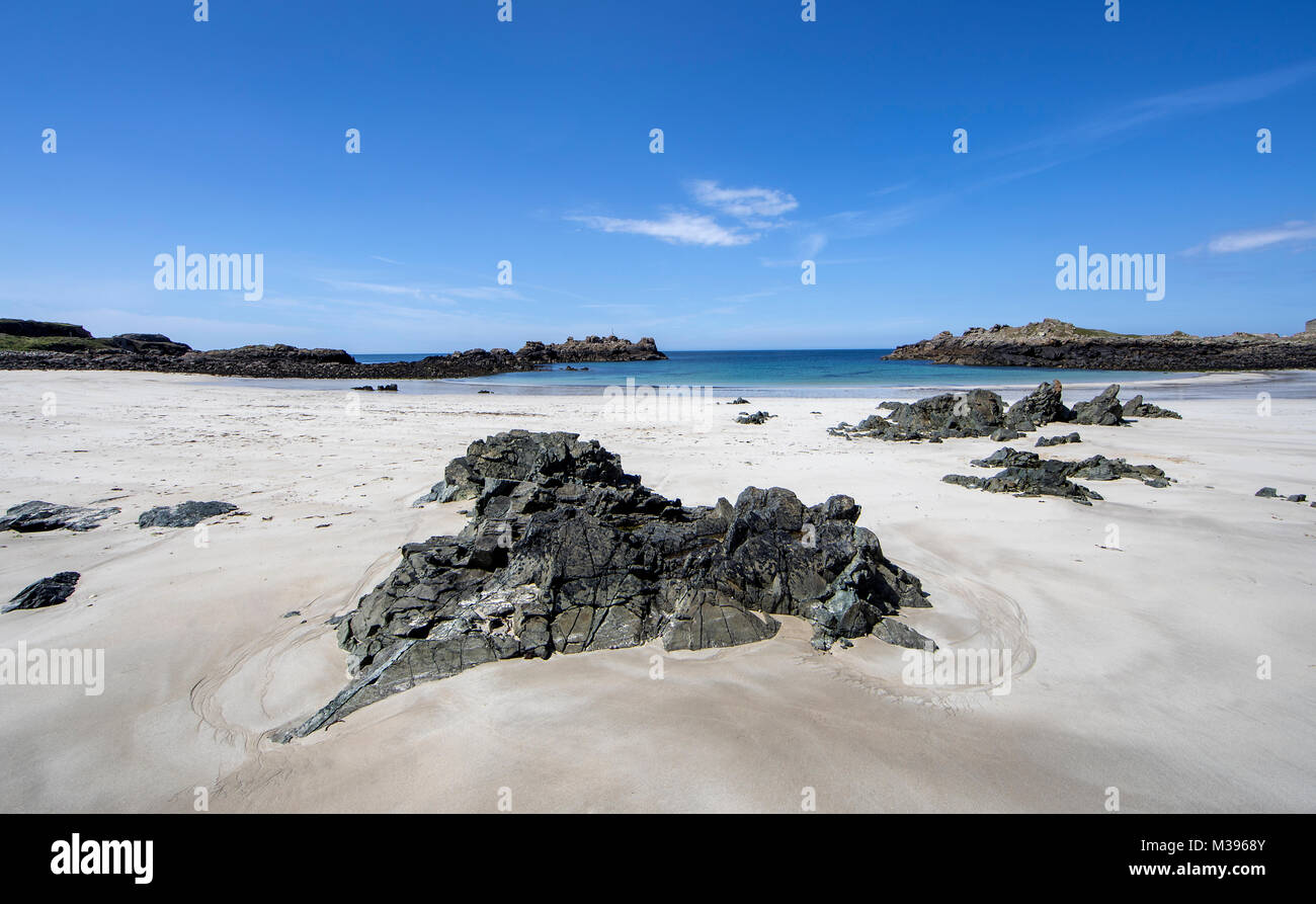 Sabbia bianca e fine e la diorite rocce sulla spiaggia Saye in Alderney Isole del Canale Foto Stock